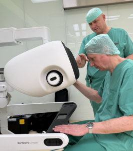 Zwei Männer schauen einen Operationsroboter an